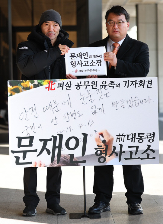 서해 피격 공무원의 형 이래진씨(왼쪽)와 김기윤 변호사가 14일 오후 서울 서초구 서울중앙지검에서 문재인 전 대통령 고소 기자회견에 앞서 고소장을 들고 있다.  이래진 씨 측은 문재인 전 대통령이 동생 이대준씨에 대한 구조조치를 지시하지 않은 점과 관련해 직무유기 혐의로, 해양경찰의 월북발표한 점과 관련해 허위공문서작성, 허위사실유포 명예훼손, 사자명예훼손 등의 혐의로 문재인 대통령을 고소한다고 밝혔다.<연합뉴스>